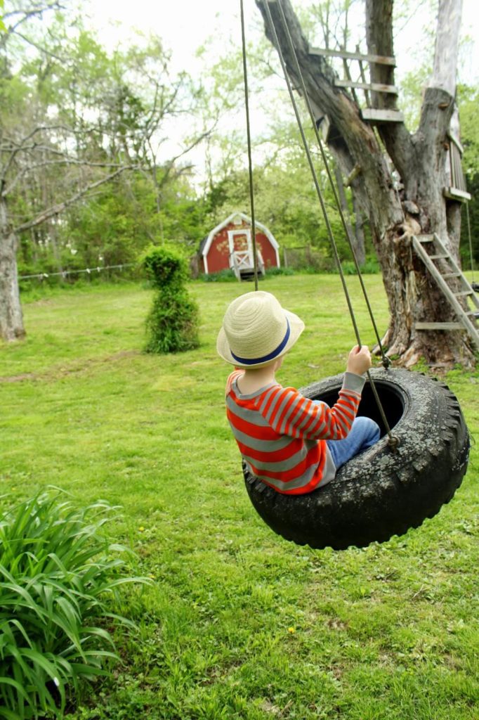 boy swinging on tire swing