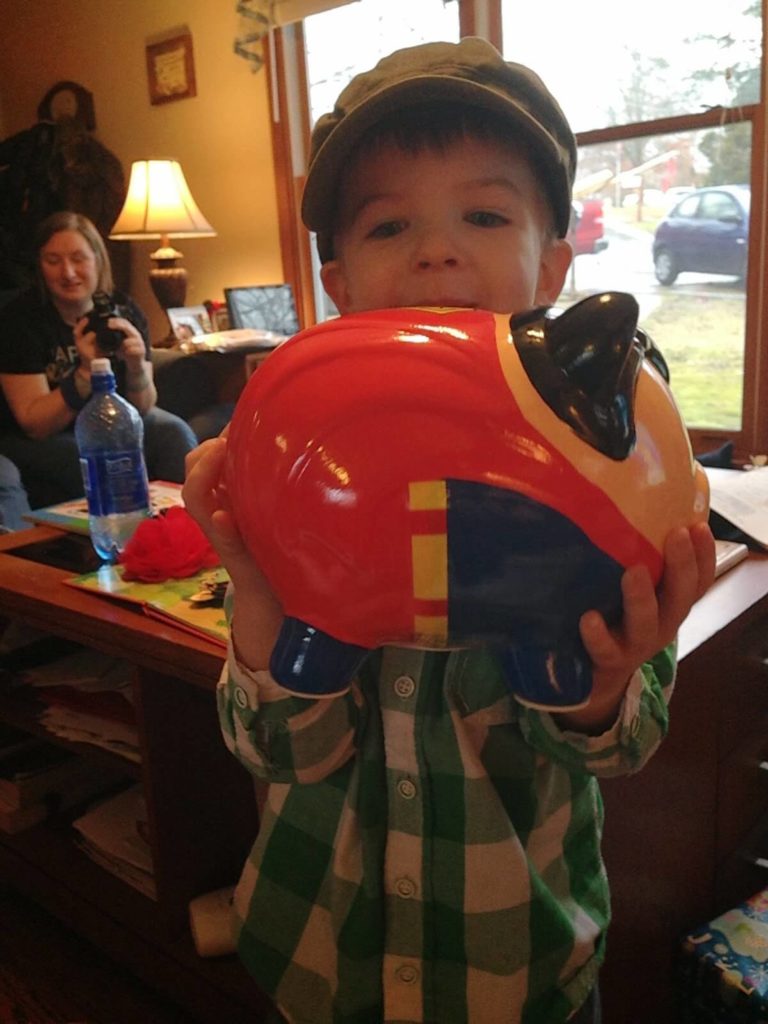 little boy holding piggy bank