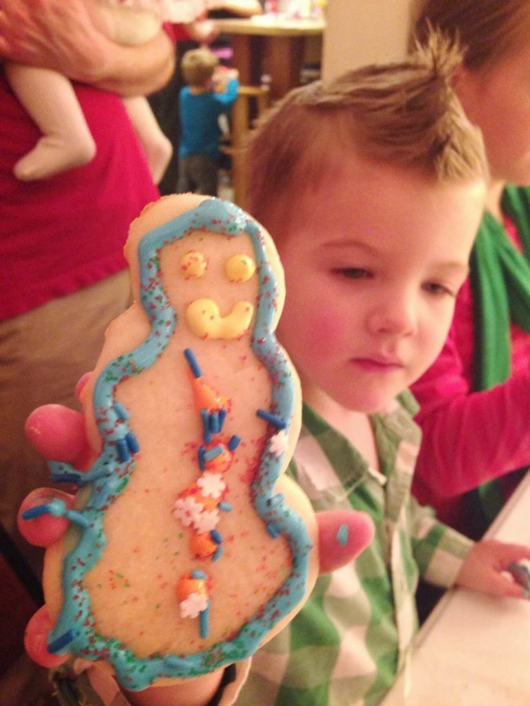 little boy showing snowman cookie