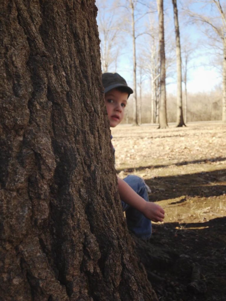 little boy playing hide and seek