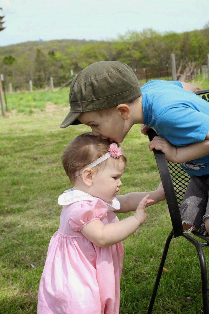 little boy kissing baby sister