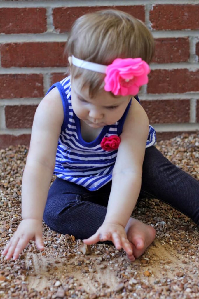 baby girl playing in rocks