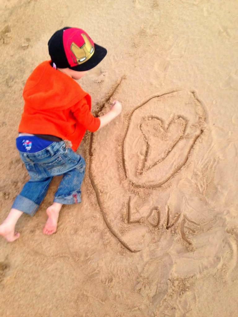 boy drawing in the sand