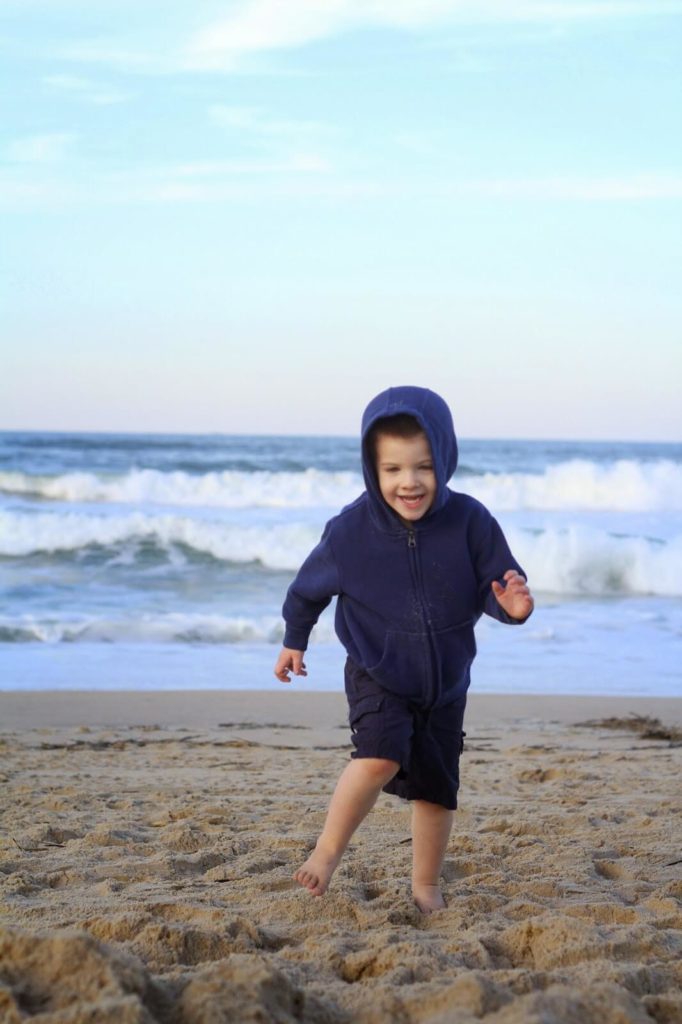 little boy running from waves