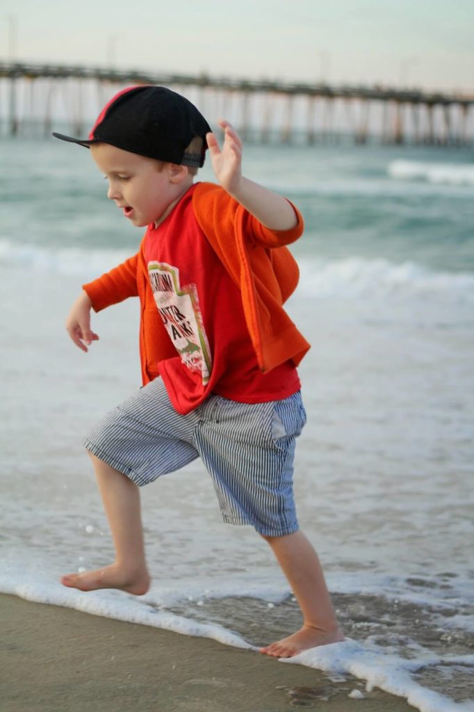 boy running from ocean waves