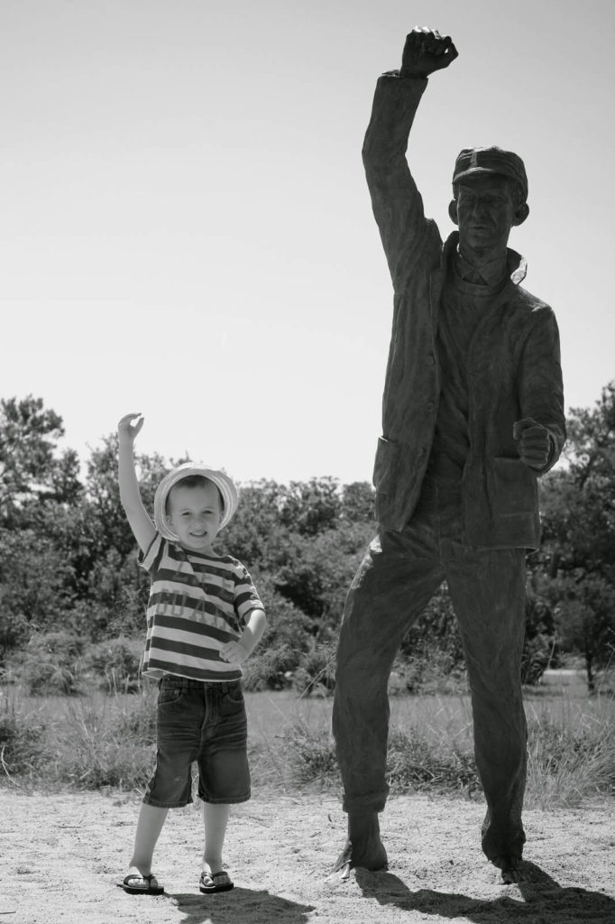 boy posing with statue