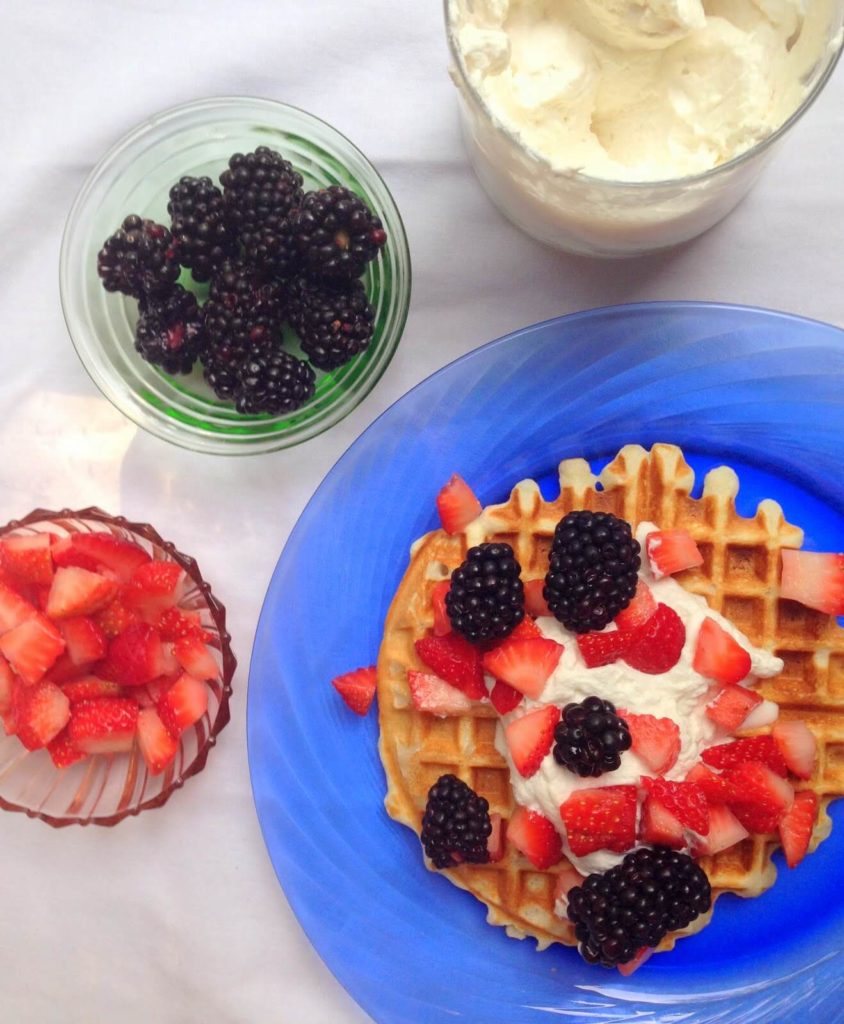 waffle with fruit topping and whipped cream