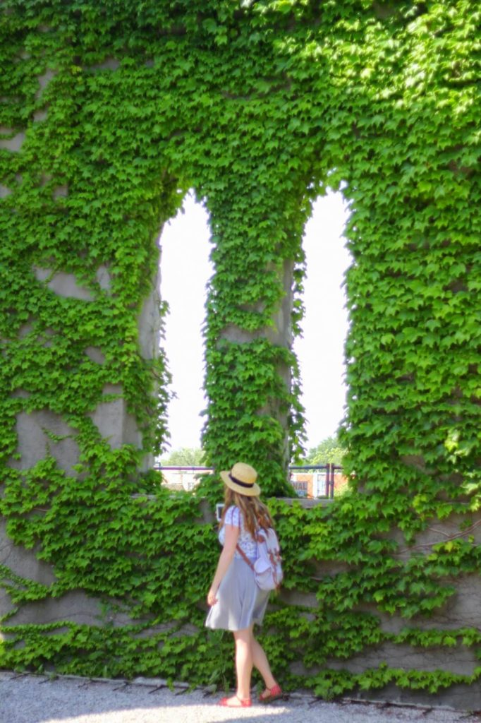 young woman by ivy wall