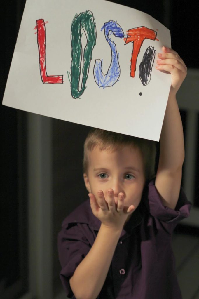 boy holding lost sign