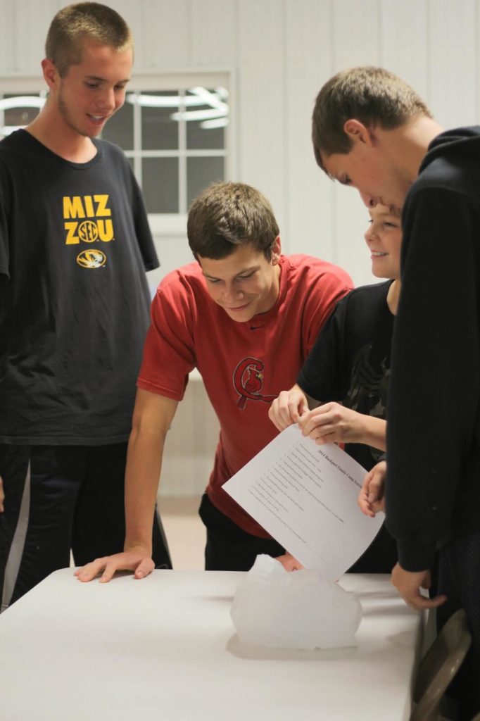 4 boys gathered around table