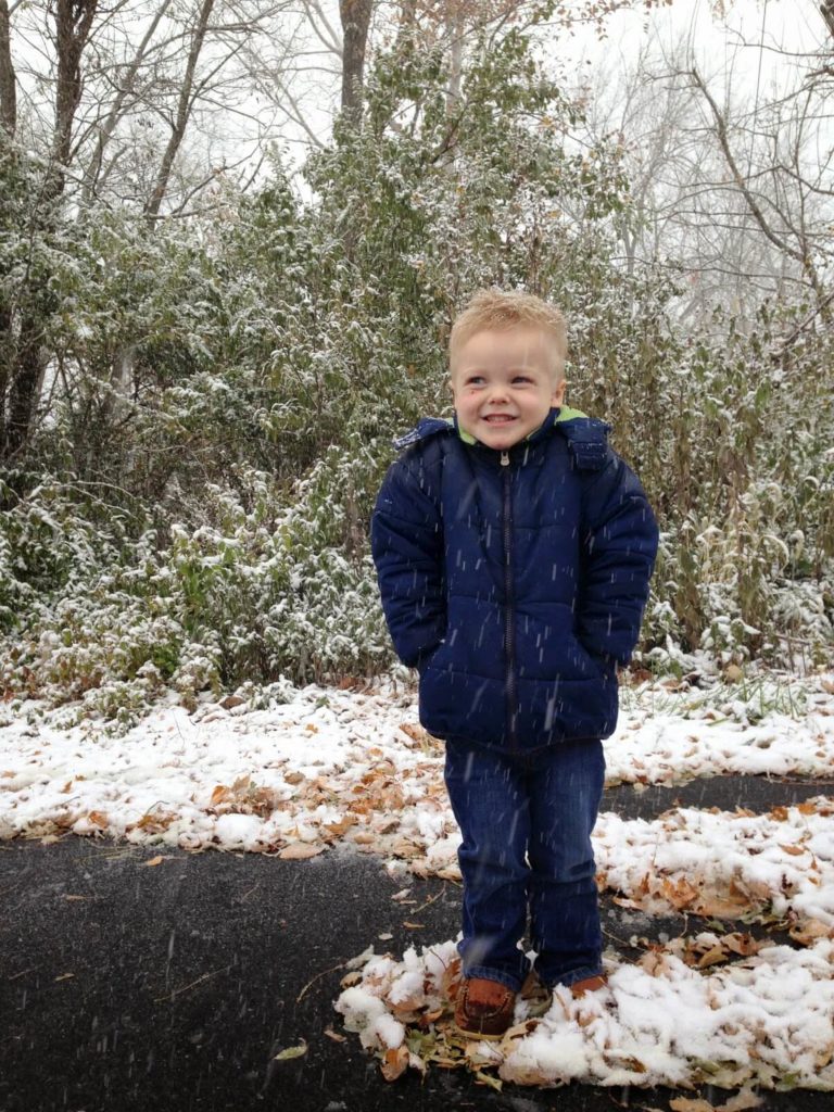 boy standing in snowfall