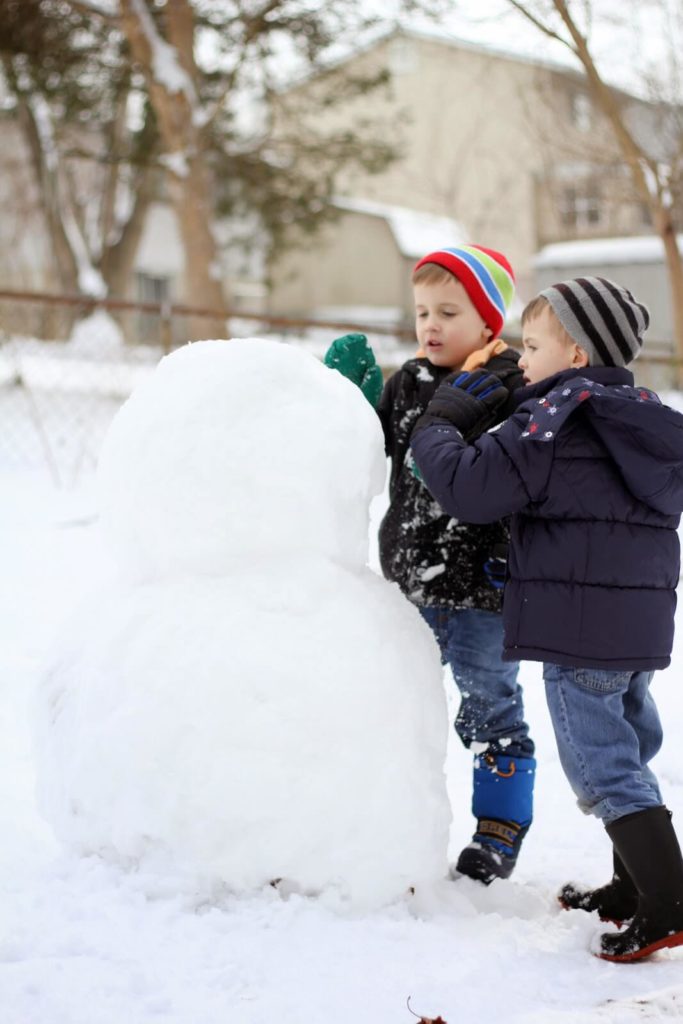 brothers building snowman