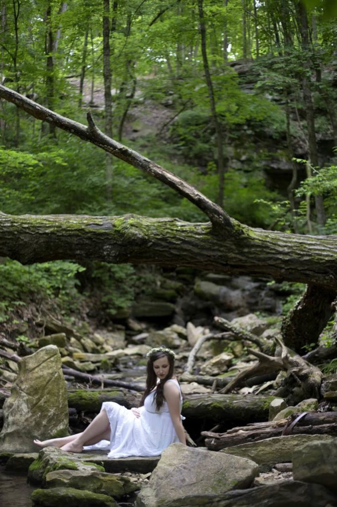 girl sitting on rocks in white dress
