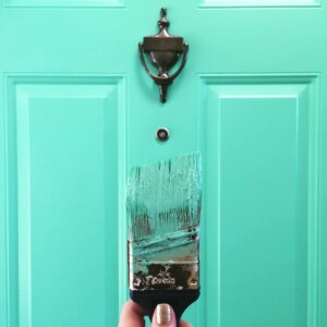 teal colored door with paint brush
