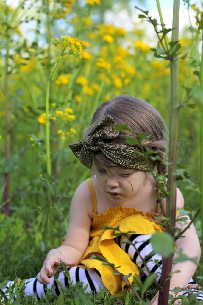 young girl in yellow dress in yellow flowers