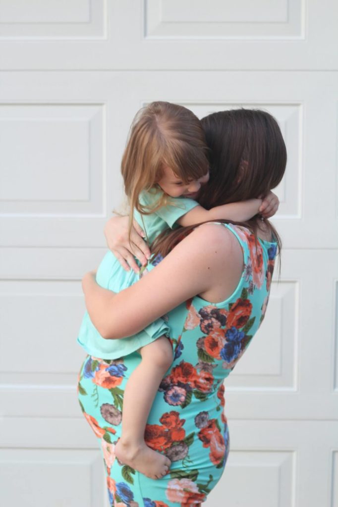 toddler girl hugging mom