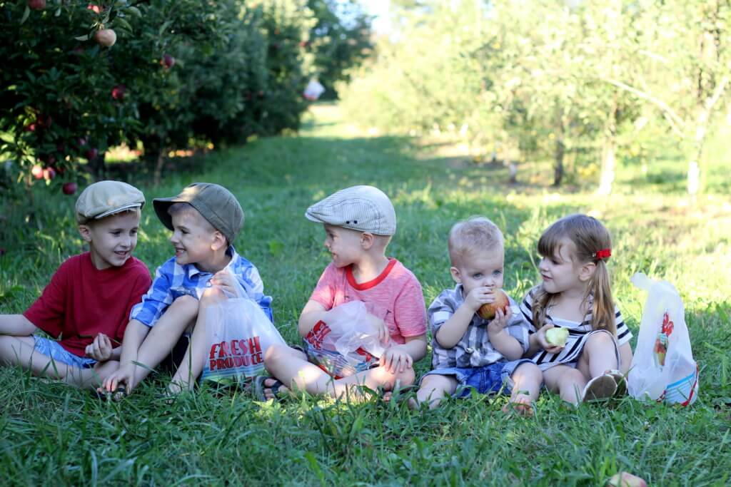 5 kids sitting in the grass