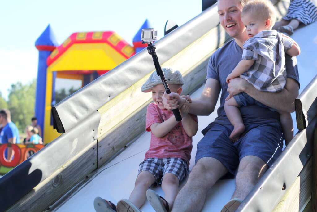 dad and boys going down a slide