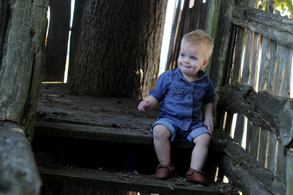 cute baby boy sitting on wooden steps