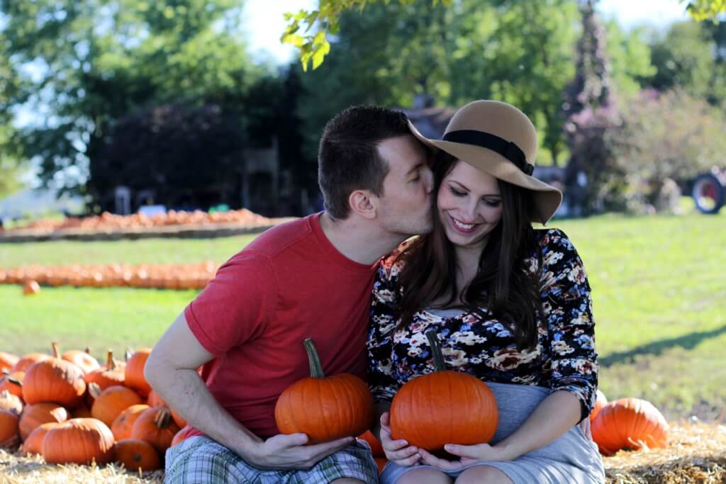 married couple kissing at the pumpkin patch