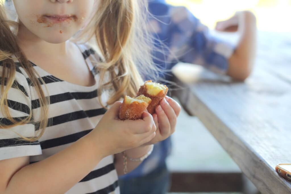 toddler girl eating an apple cinnamon donut