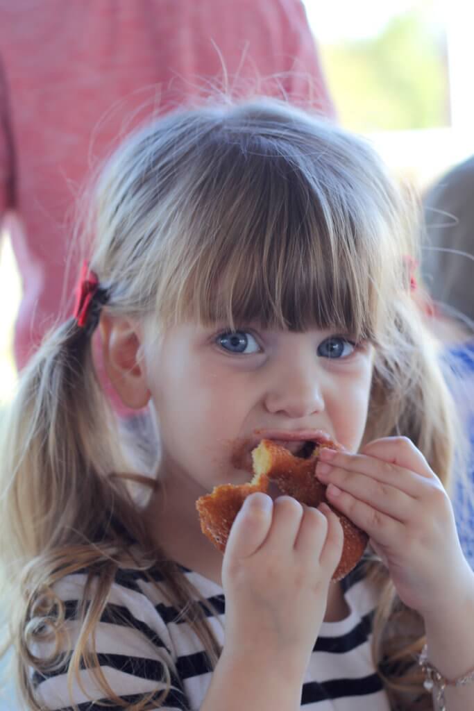 girl taking bites of the donut